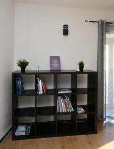 a black book shelf in a room with books at Sweet Home in Capua