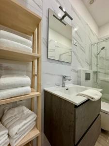 uma casa de banho com lavatório, espelho e toalhas em The Urban Loft em Ljubljana