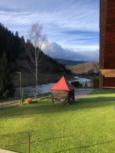 een prieel met een rood dak op een grasveld bij River House in Jaremtsje +31 foto's
