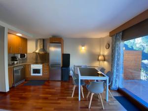 a kitchen and dining room with a table and chairs at La Mola de Prats Canillo in Meritxell