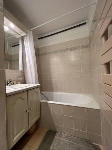 La salle de bains est pourvue d'une baignoire et d'un lavabo. dans l'établissement L'Appartement des Sables, au Lavandou