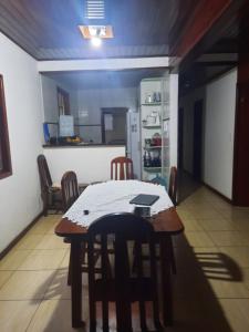 Una cocina con mesa y sillas y un refrigerador. en Casa praia dos anjos, en Arraial do Cabo 1 foto más