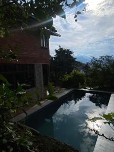 a swimming pool in front of a house at Café Tinto Cabaña Rústica in Coroico +6 photos