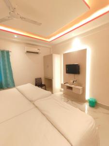 a hotel room with two beds and a flat screen tv at S.S Guest House in Varanasi