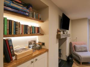 a room with a shelf with books and a chair at St Mary's Cottage in Windermere