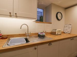 a kitchen with a sink and a clock on the wall at St Mary's Cottage in Windermere +19 photos