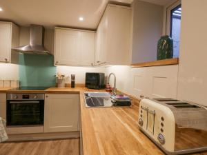 a kitchen with white cabinets and a toaster at St Mary's Cottage in Windermere
