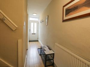 a hallway with a staircase with a table and a door at St Mary's Cottage in Windermere