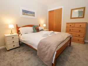a bedroom with a large bed and a dresser at St Mary's Cottage in Windermere