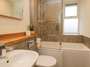 a bathroom with a sink and a toilet and a shower at St Mary's Cottage in Windermere