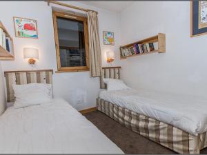 two twin beds in a room with a window at Appartement Val-d'Isère, 5 pièces, 8 personnes - FR-1-518-104 in Val-d'Isère