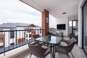 a balcony with a table and chairs on it at Ballito Hills Luxury Apartments in Ballito