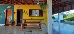 Zimmer mit einem Tisch und einer gelben Wand in der Unterkunft HOSPEDARIA TUCUNA in Presidente Epitácio