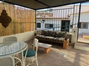 een patio met een bank en een tafel en stoelen bij Casa Las Cuevas in Málaga