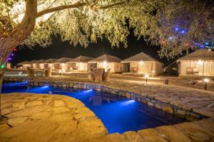 a resort with a swimming pool at night at Tripli Hotels Stay Inn Resort Jaisalmer in Sām