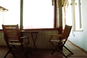 Dos sillas y una mesa en una habitación con ventana. en Aivani 8, en Tiflis