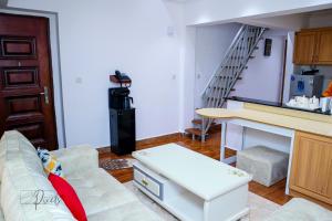 a living room with a couch and a stair case at Sturdy Stays KAHAWA WEST in Nairobi