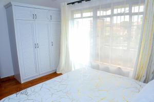 a bedroom with a bed and a large window at Sturdy Stays KAHAWA WEST in Nairobi