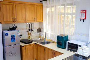 a kitchen with a white refrigerator and a sink at Sturdy Stays KAHAWA WEST in Nairobi