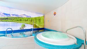 a bathroom with a tub with a view of a river at Apartamenty Good Time- Stone Hill II in Szklarska Poręba