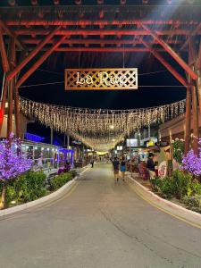 a walkway in a shopping center with lights and flowers at Pousada Ecos do Mar in Praia do Frances