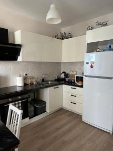 cocina con armarios blancos y nevera blanca en Superb residence,pool,gym,sauna, en Estambul