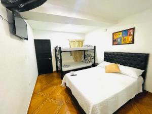 1 dormitorio con 1 cama y TV. en Hotel Tradicional Villeta en Villeta