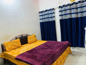 a bedroom with a bed with blue and yellow sheets at Udaipur Stays 2 in Udaipur