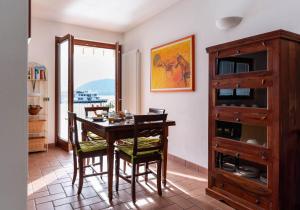a dining room with a table and chairs and a window at By the Lake 29 - Menaggio by LoveComo in Menaggio