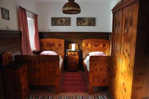 um quarto com 2 camas e armários de madeira em Wohnung Gasteg em Maria Alm am Steinernen Meer