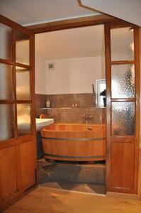 uma casa de banho com uma banheira de madeira e um lavatório em Wohnung Gasteg em Maria Alm am Steinernen Meer