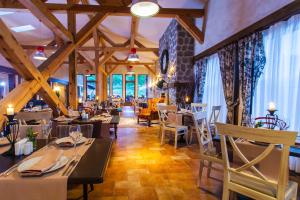 un restaurante con techos de madera, mesas y sillas en Green Life Bansko en Bansko