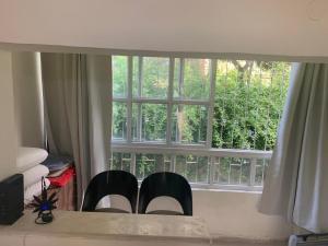 two black chairs sitting in front of a window at משמר הגבול 9 דירה 4 in Haifa
