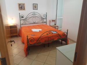 ガリポリにあるAppartamenti Boito Lido San Giovanniのベッドルーム1室(オレンジ色の毛布付きのベッド1台付)