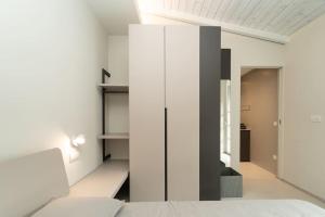 科莫的住宿－Appartamento moderno a 2 minuti dal duomo di Como，一间拥有白色墙壁、一张床和一个衣柜的房间