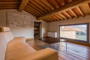 uma sala de estar com um sofá e uma grande janela em Nello's, Villa di pregio con SPA em Cortona