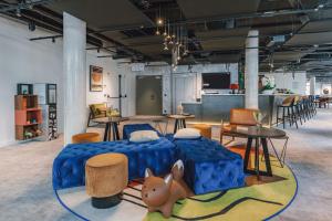 une chambre avec un lit, des tables et des chaises dans l'établissement Appart'City Collection Paris Gare de Lyon, à Paris