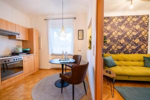 ein Wohnzimmer mit einem gelben Sofa und einem Tisch in der Unterkunft Modernes Appartement in Graz