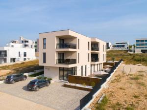 un edificio con un'auto parcheggiata in un parcheggio di Villa Sorriso a Sveti Filip i Jakov (Santi Filippo e Giacomo)