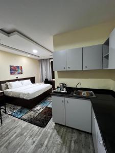 伊巴丹Fragrance Apartments and Suites的酒店客房设有一张床和一个带水槽的厨房