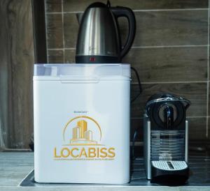 a white cooler sitting next to a coffee maker at Locabiss studio meublé in Rufisque