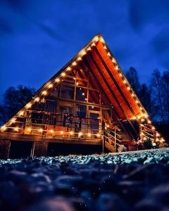 uma casa com luzes à noite em Zenith A-Frame Straja em Lupeni