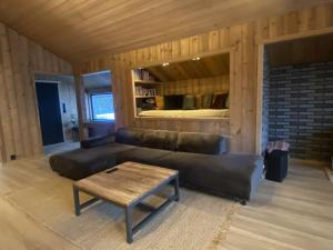 a living room with a leather couch and a coffee table at Newly renovated apartment with a central location in Geilo