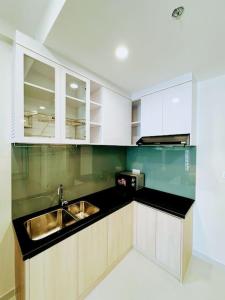 eine Küche mit weißen Schränken und einem Waschbecken in der Unterkunft Experience Luxury Living! Spectacular 1-Bedroom Apartment in Thuan An, Binh Duong in Thuan An
