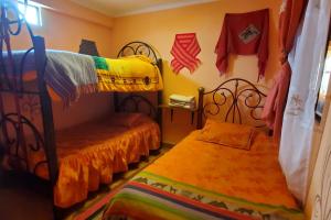 Łóżko lub łóżka piętrowe w pokoju w obiekcie Hostal Golden Quinua