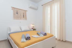 a white bedroom with a bed with towels on it at SeaView Apartment 1 in Samos