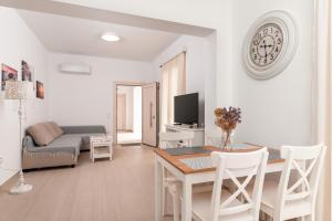 a living room with a table and a clock on the wall at SeaView Apartment 1 in Samos