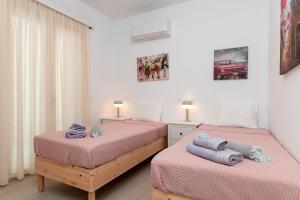 two twin beds in a room with two lamps at SeaView Apartment 1 in Samos