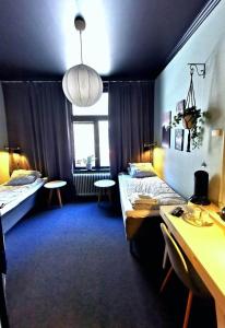 a room with two beds and a desk in it at Hotell Temperance in Hudiksvall