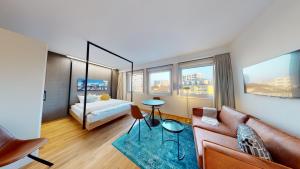 a living room with a couch and a bed at LivingTown Lofts Zurich in Zurich